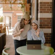 A woman sitting at a table using a laptop.