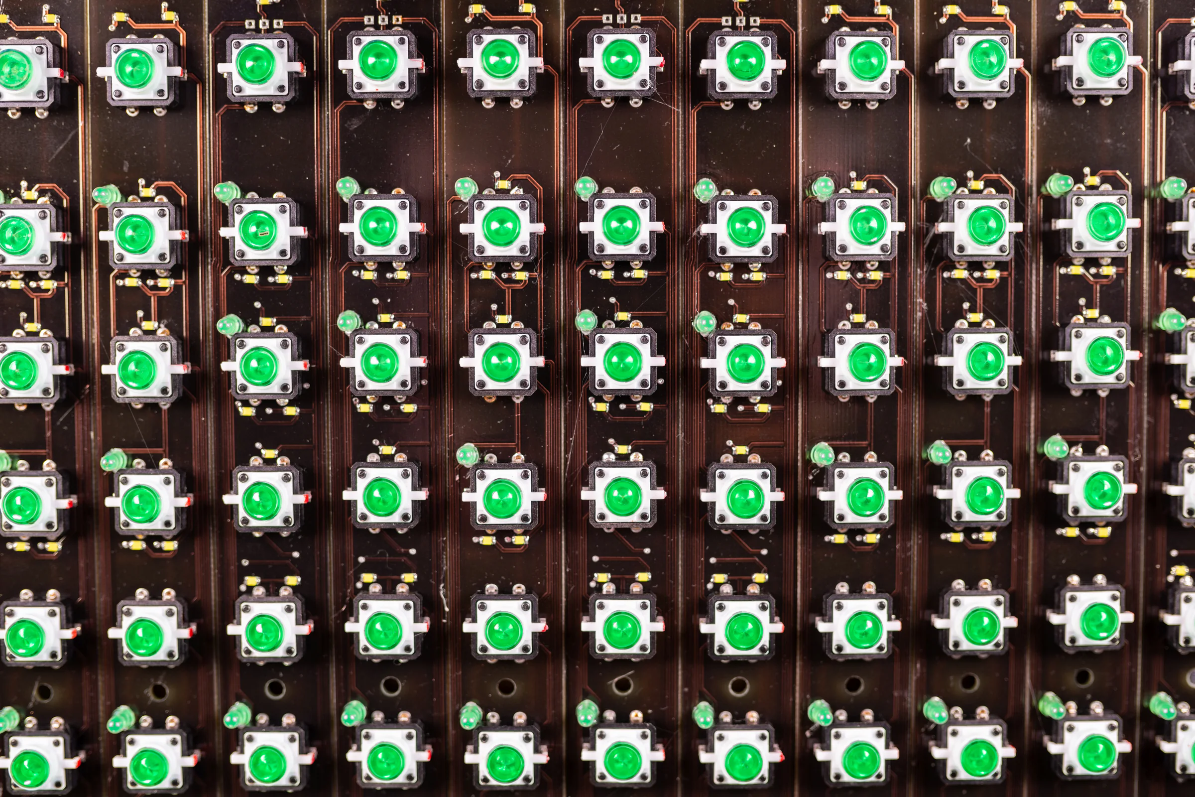 Rows of illuminated green controls on a circuit board