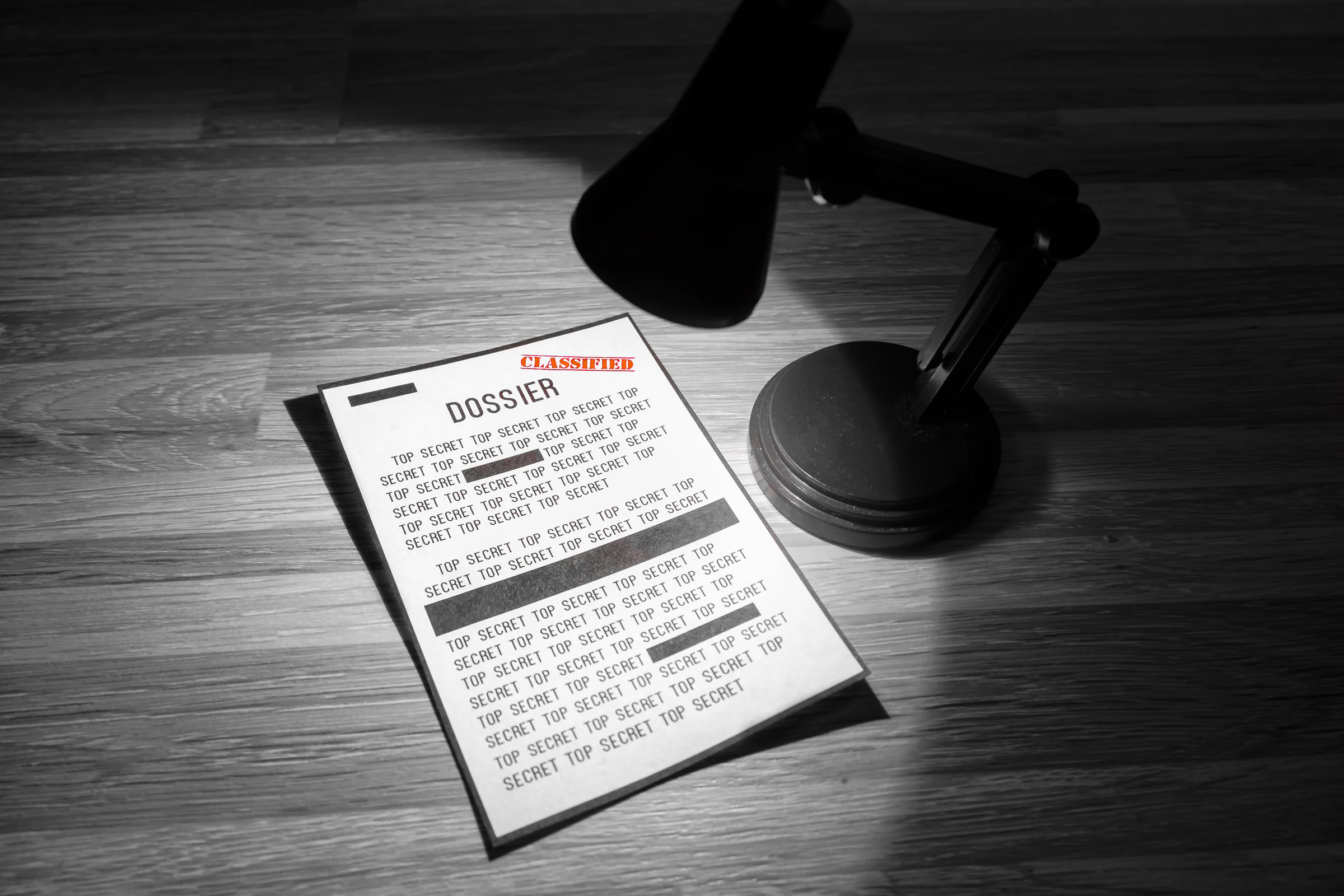 Printed business plan reviewed beneath a desk lamp