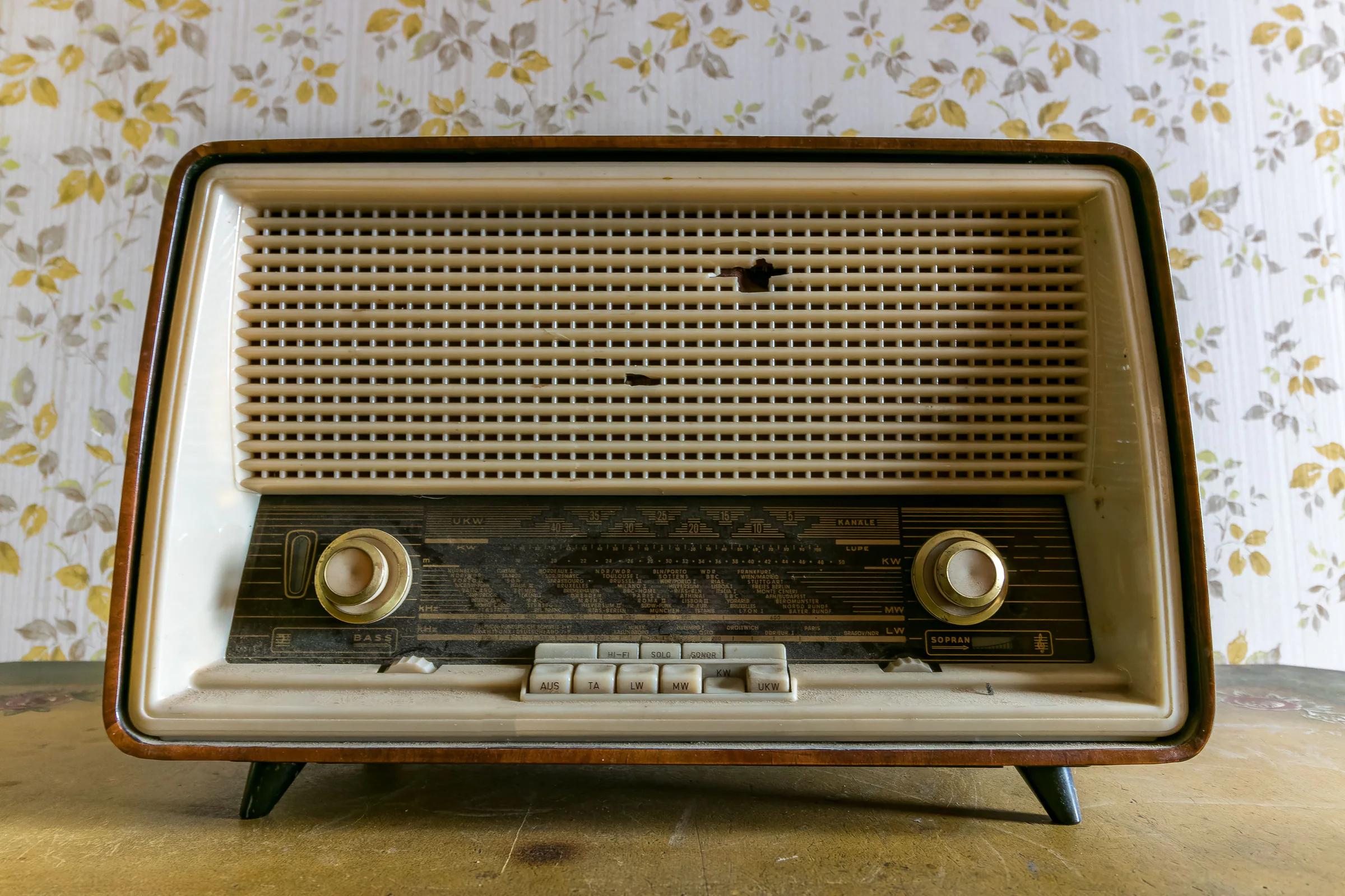 Vintage radio on a table against patterned wallpaper