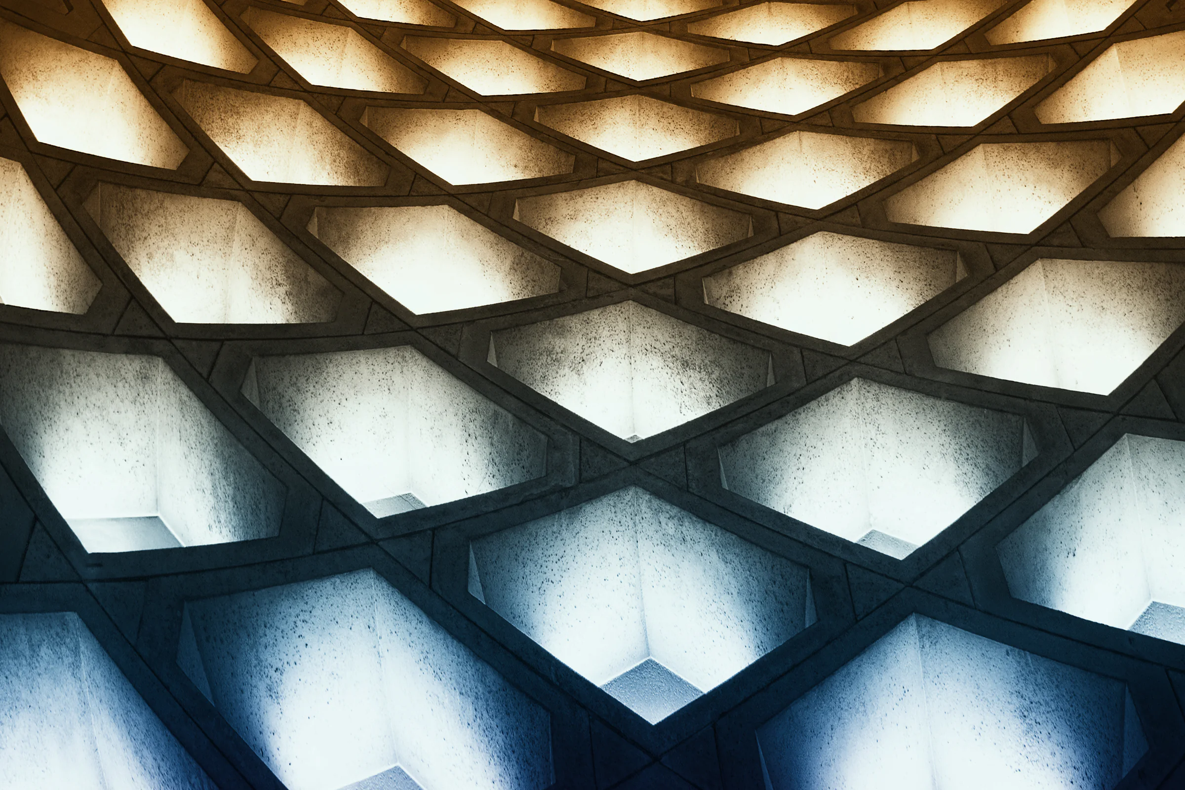 Geometric concrete ceiling lit in blue and yellow